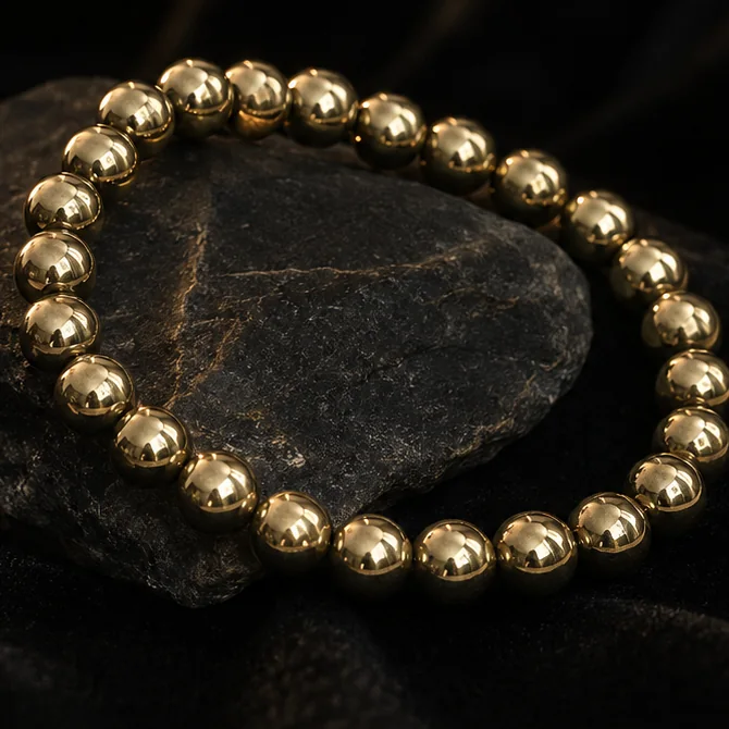 Metallic gold-tone Pyrite Bracelet displayed in a hand